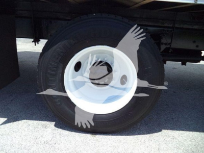 Freightliner M2 106 wheel and tire under truck chassis showing white hub and black tire