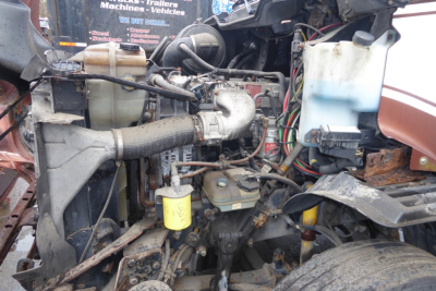 Engine bay of a 2009 Freightliner CL112 with visible hoses, reservoirs, and components.