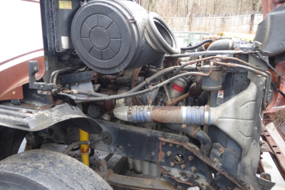 Engine bay view of 2009 Freightliner CL112 conventional daycab showing exposed engine components and hoses.
