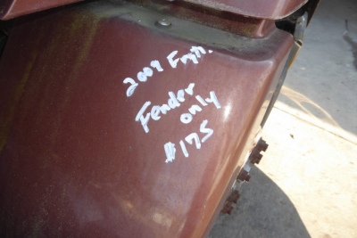 2009 Freightliner CL112 side panel with white handwritten notes '2007 F....' 'Fender only $175' on maroon surface
