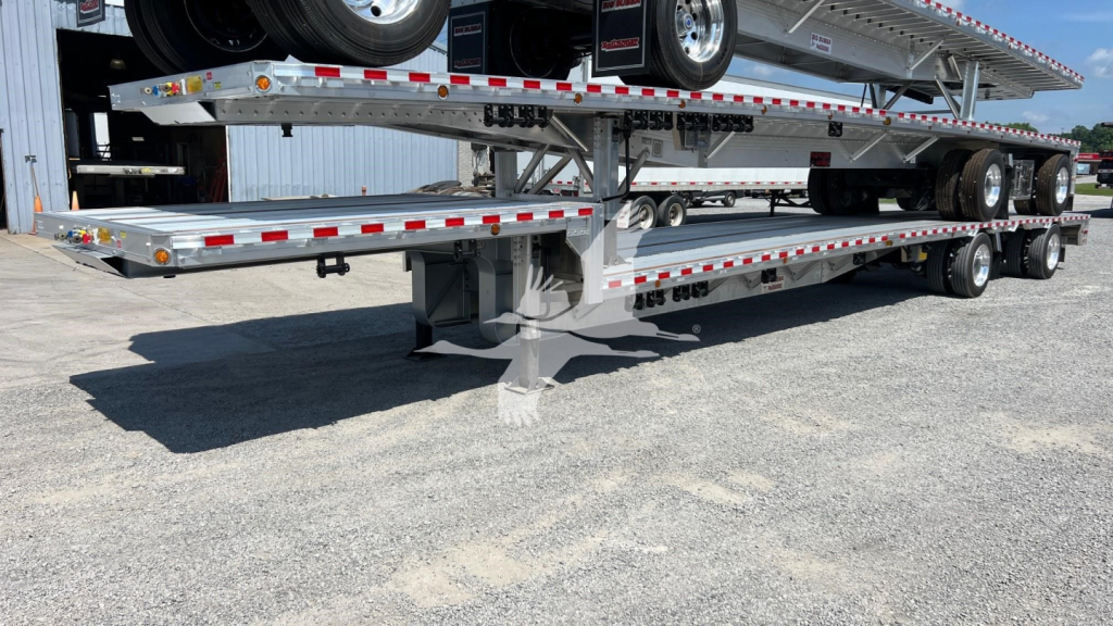 Dropdeck trailer with multiple axles and Spare tire on upper deck showing RGN-style deck and loading ramps.