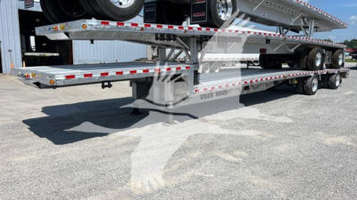 Truck trailer showing dropdeck trailer with tandem axles and reflective tape along sides.