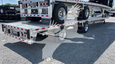Trailer view showing Reitnouer Big Bubba Dropdeck with dual rear ramps and chrome wheels, stacked on a drop deck trailer.