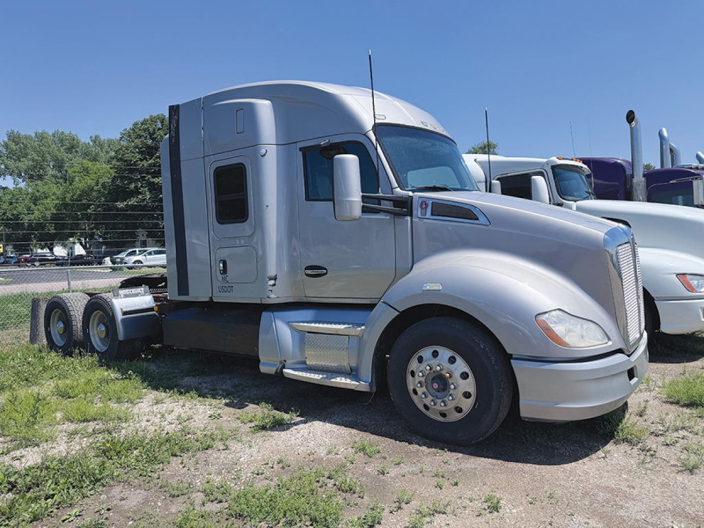 Kenworth T680 tractor cab side view showing wheels, silver exterior, and sleeper compartment.