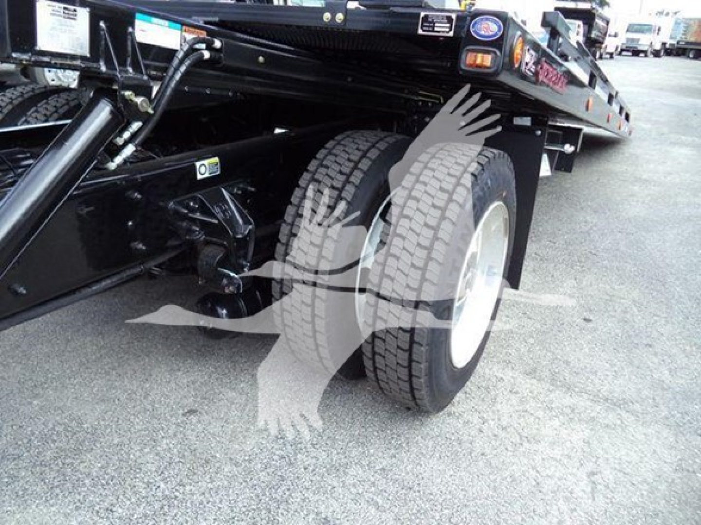 Kenworth T280 rollback truck chassis showing dual rear wheels and hydraulic hitch components.