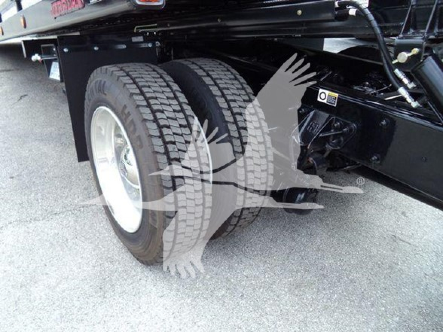 Kenworth T280 rollback truck rear dual wheels showing tire treads and suspension components.