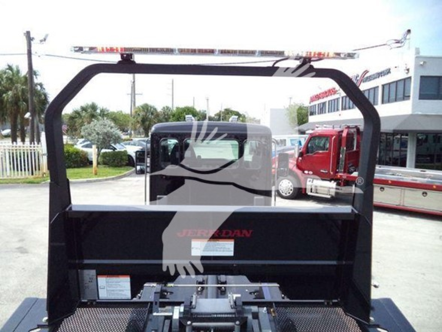 Kenworth T280 rollback bed area with hydraulic boom and frame, rear view showing Jerr-Dan branding and truck cab in background.