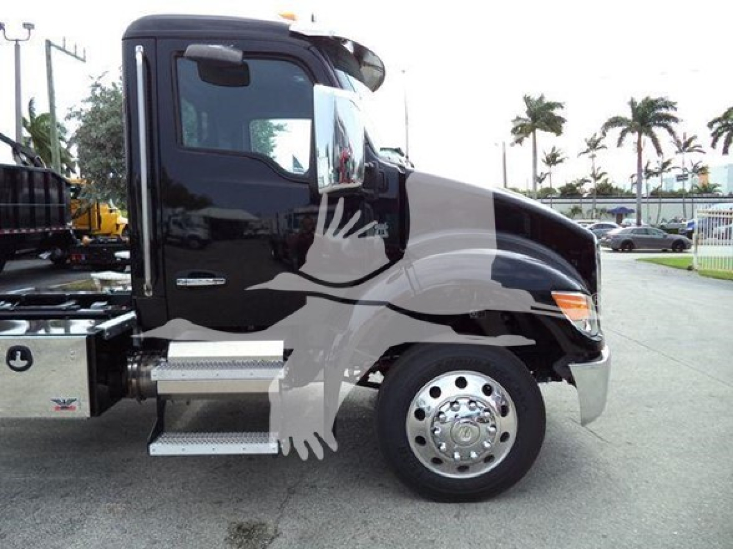 Kenworth T280 rollback truck with black cab and side steps, showing front wheel and door area.