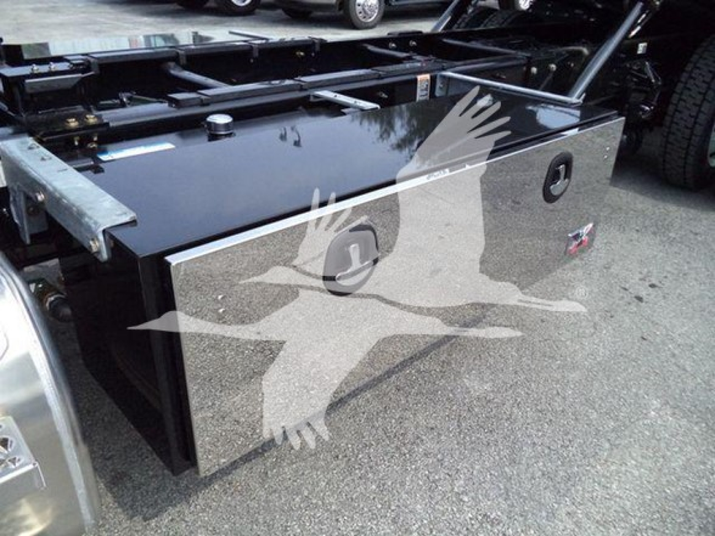 Kenworth T280 rollback truck bed toolbox with glossy black surface showing two circular access hatches and chrome trim.