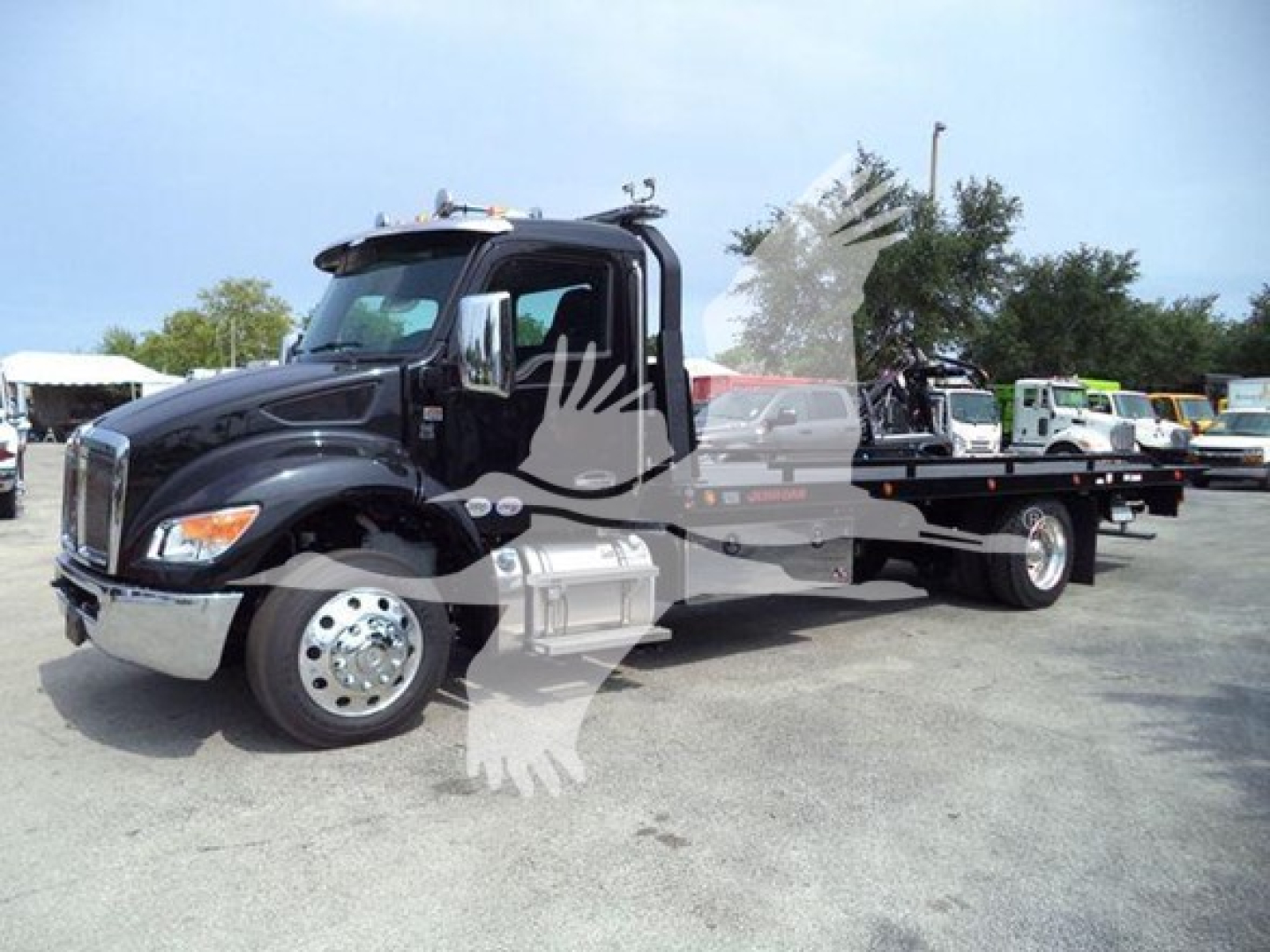 Kenworth T280 rollback truck in black with attached flatbed, side view showing cab and front grille, stock number J40823.