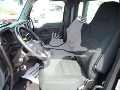 Truck cab interior of a 2025 Kenworth T280 showing steering wheel, driver seat, and front passenger seat.