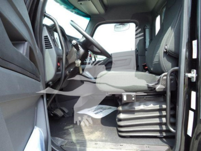 Kenworth T280 cab interior view showing steering wheel, driver's seat, and dashboard from open door.