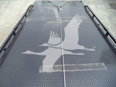 Kenworth T280 rollback truck deck showing textured metal surface with white birds graphic and chain tie-downs.