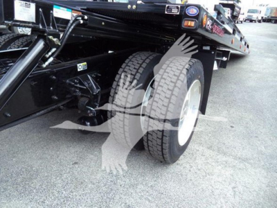 Kenworth T280 rollback truck chassis showing dual rear wheels and hydraulic hitch components.