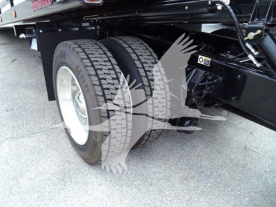 Kenworth T280 rollback truck rear dual wheels showing tire treads and suspension components.