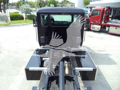 Kenworth T280 rollback truck cab rear view showing chassis and hitch area with black toolboxs on either side and hitch pin in center.