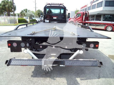 Kenworth T280 rollback flatbed showing rear view with loading ramp and winch points, taillights, and diamond plate bed.