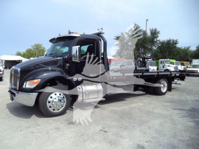 Kenworth T280 rollback truck in black with attached flatbed, side view showing cab and front grille, stock number J40823.