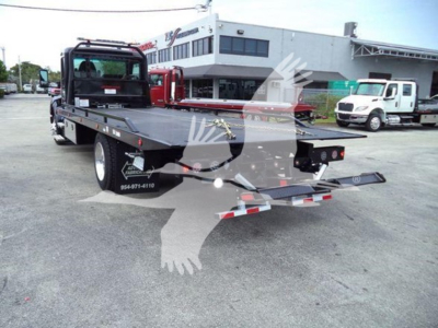 Kenworth T280 rollback truck with flatbed and rear loading ramps in a dealership lot; VIN and stock number visible on the image; white and gray building in background.