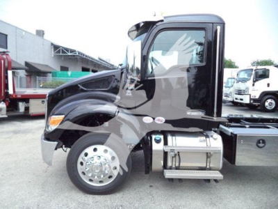 Truck cab side profile of a 2025 Kenworth T280 in black, with chrome fuel tank, front wheel and door badge visible.