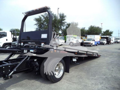 Kenworth T280 rollback truck bed with hydraulic tilt and steel frame, rear wheels visible, dealership lot in background.
