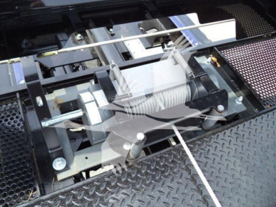 Kenworth T280 rollback truck setup showing winch and hydraulic reels and metal diamond plate surface.