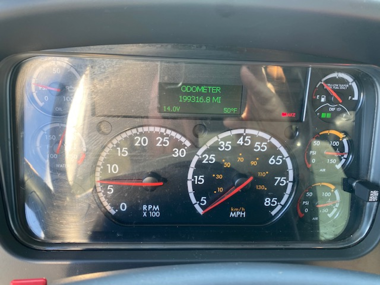Dashboard of a Freightliner M2 106 showing odometer 199316.8 miles, RPM x1000 gauge, speedometer with MPH, green ODOMETER display, green 14.0V, fuel and various gauges.