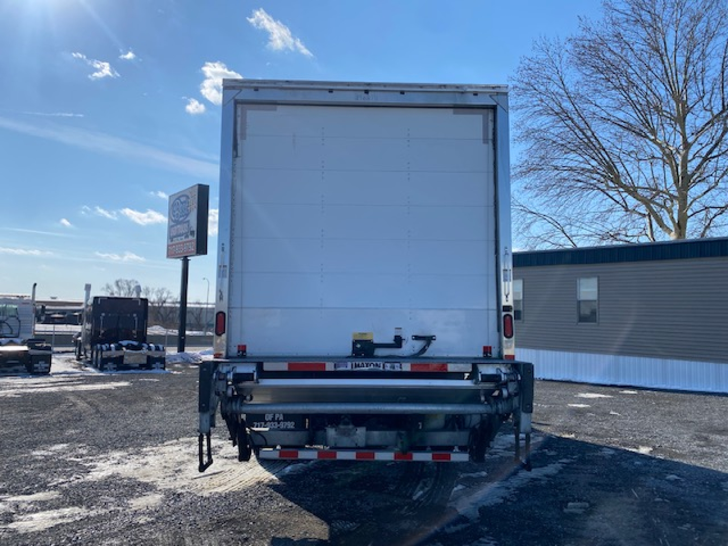 Freightliner M2 106 rear view showing box truck cargo area and rear bumper with reflectors.