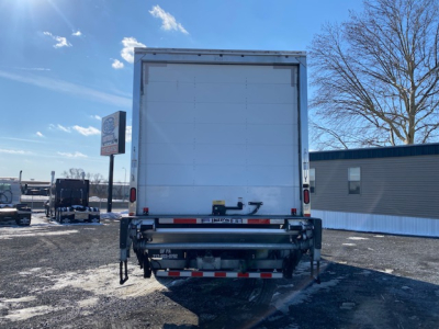 Freightliner M2 106 rear view showing box truck cargo area and rear bumper with reflectors.