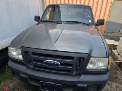 Ford Ranger pickup truck front view showing cap and grille with Ford emblem, gray bumper, headlights, and windshield.