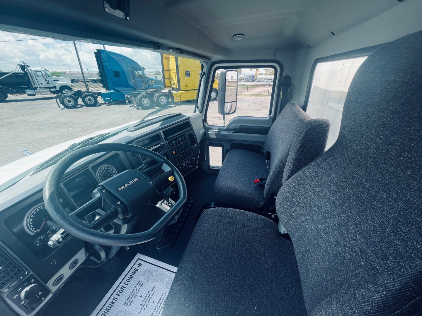 Mack MD6 cab interior showing steering wheel dash and driver seat with dashboard controls.