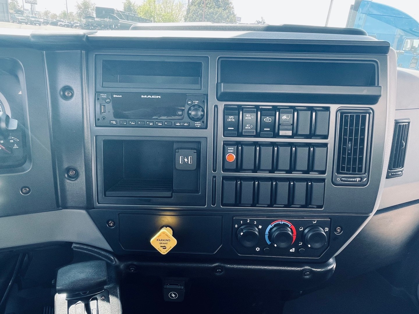 Dashboard view of a 2026 Mack MD6 showing infotainment display, multiple control switches, climate controls, and a yellow warning placard. VIN visible in listing context.