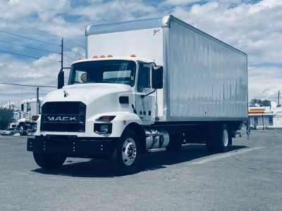 Box truck front three-quarter view showing 2026 Mack MD6 with white cab and large box body, VIN 1M2MDBAA2TS018612 visible in listing context.