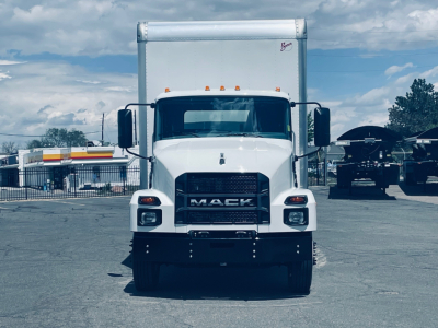 Front view of a white 2026 Mack MD6 box truck showing front grille with Mack logo and headlights, cargo box in background.