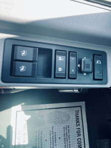 Interior switch panel showing window controls and ride height/parking brake switches in Mack MD6 cab.