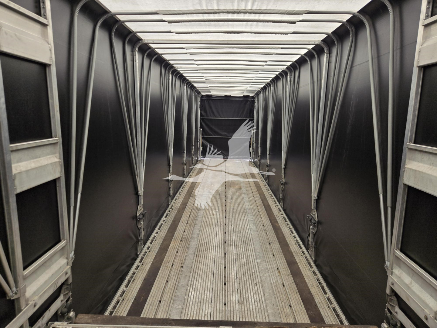 Interior of a used 2019 Mac Drop Deck trailer showing aluminum side rails, corrugated floor, and a long central aisle with ramp at far end.