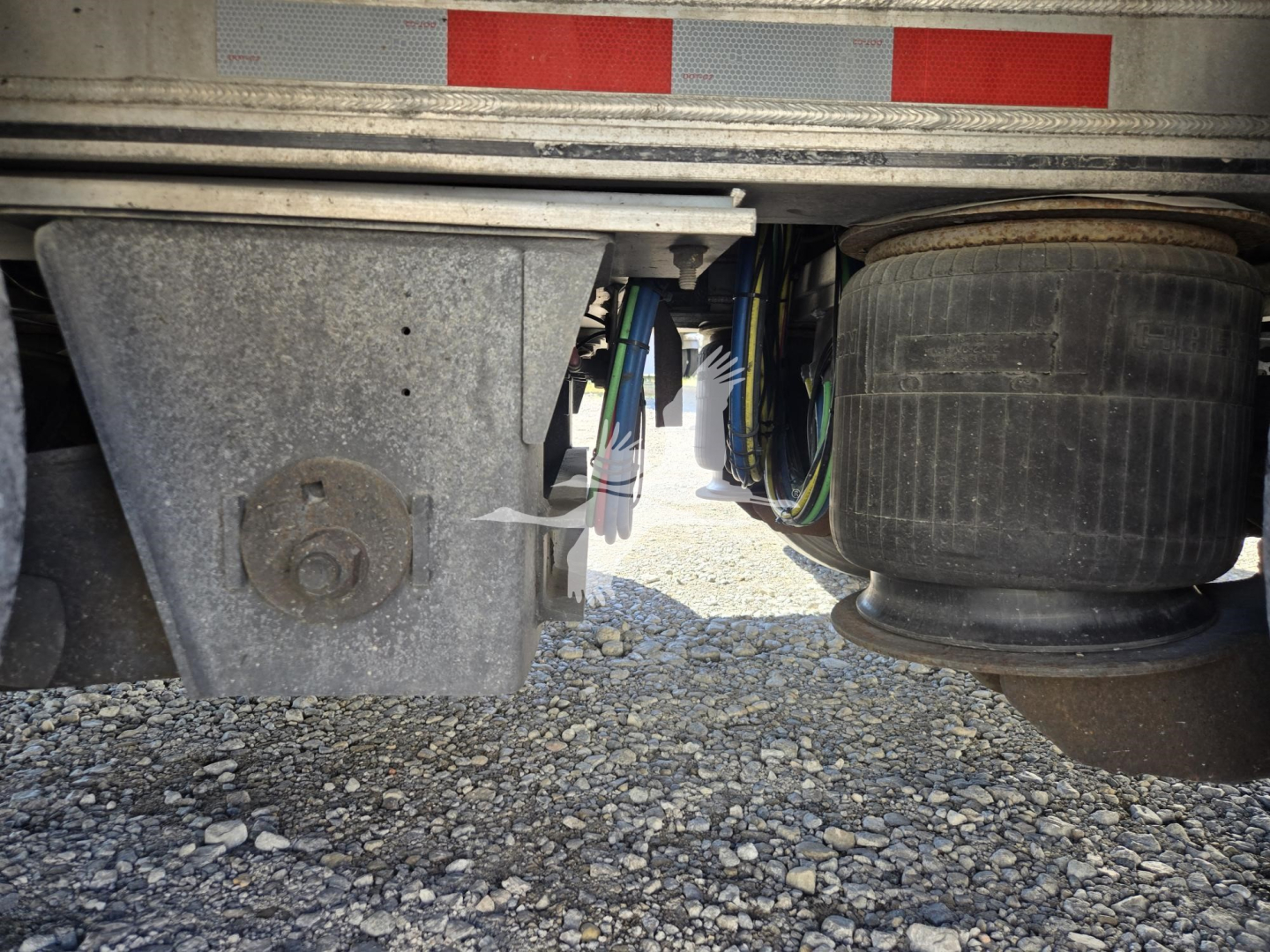Trailer undercarriage showing wheel, suspension, and side components of a 2019 Mac drop deck trailer.