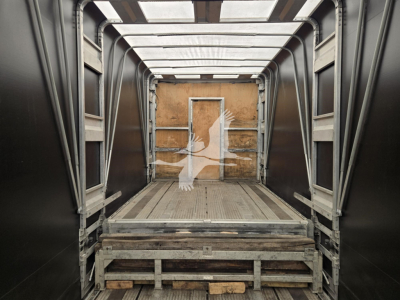 Interior of a 2019 Mac Drop Deck trailer showing loading area with wooden back wall and metal framing; rear door opening visible.
