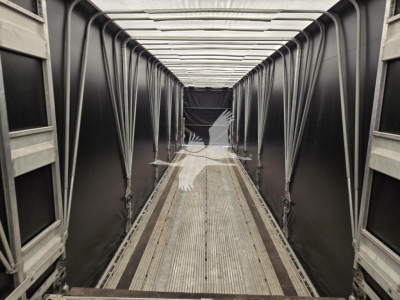 Interior of a used 2019 Mac Drop Deck trailer showing aluminum side rails, corrugated floor, and a long central aisle with ramp at far end.