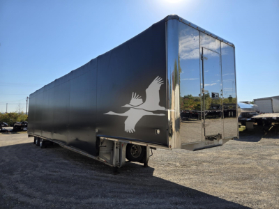 2019 Mac drop deck trailer side view showing logo graphic and rear access door.