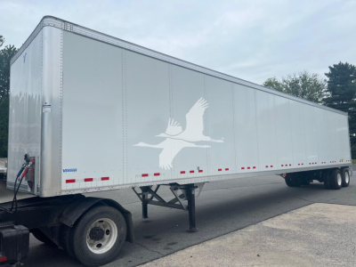 Vanguard VXP trailer showing long silver cargo body with white gull logo and lower red/white reflective markers.