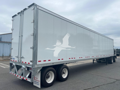 Vanguard VXP trailer side view showing large white gull logo and reflective red/white safety stripe along lower edge.