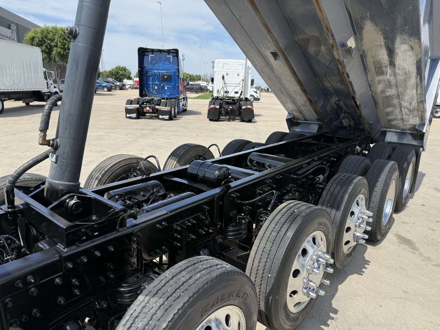 Volvo VHD dump truck chassis showing raised dump bed, dual rear axles with multiple wheels, and metal suspension components