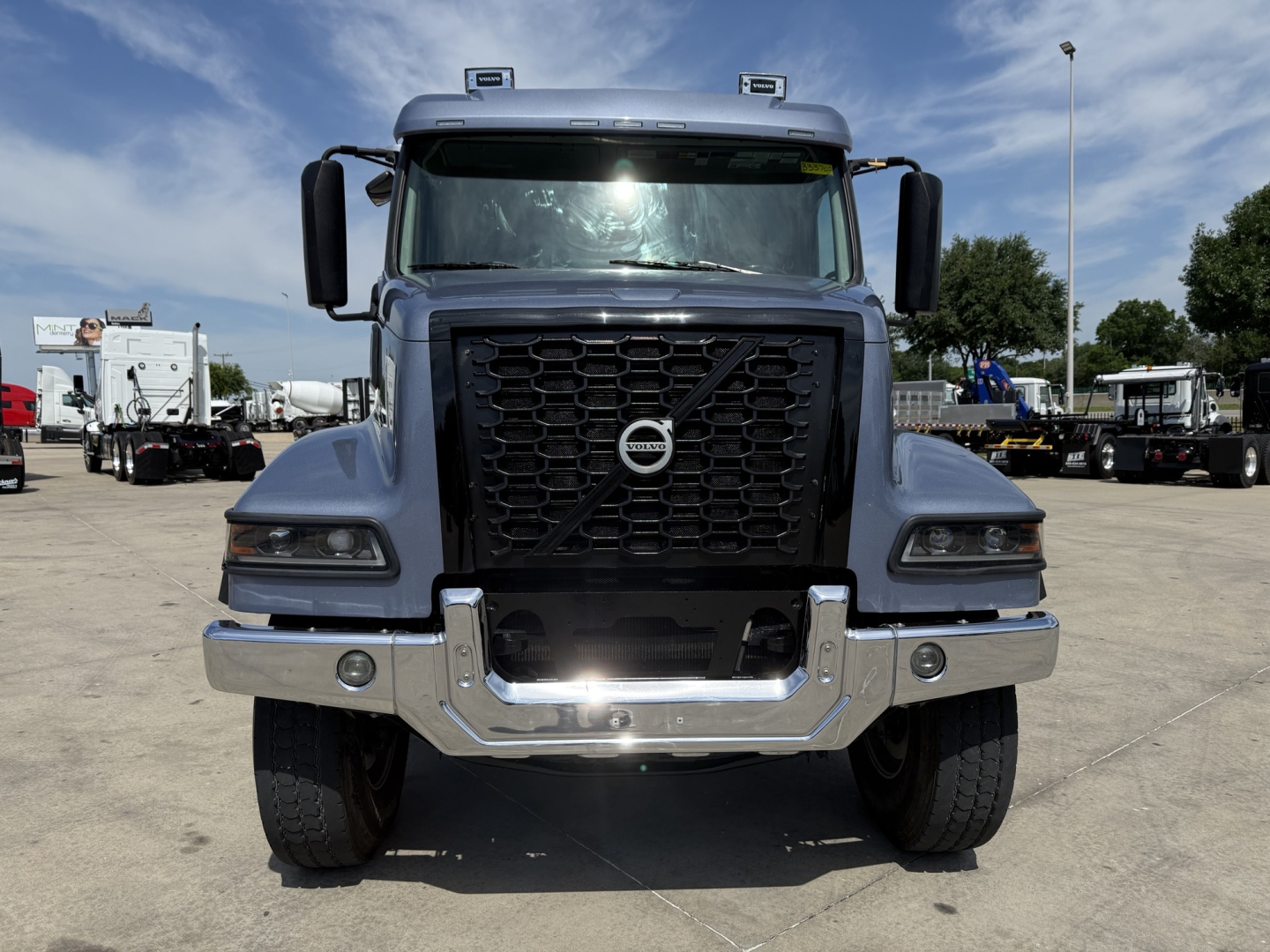 Volvo VHD truck front view showing grille with Volvo emblem, headlights, and chrome bumper.