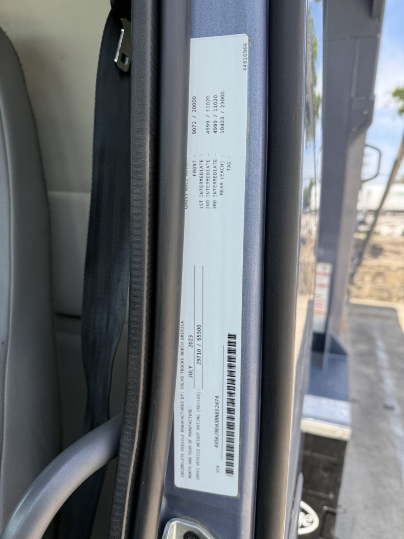 Door jamb label with vehicle and VIN information visible on a Volvo VHD104F300 truck. Text includes VIN, build dates, weights, and barcodes.