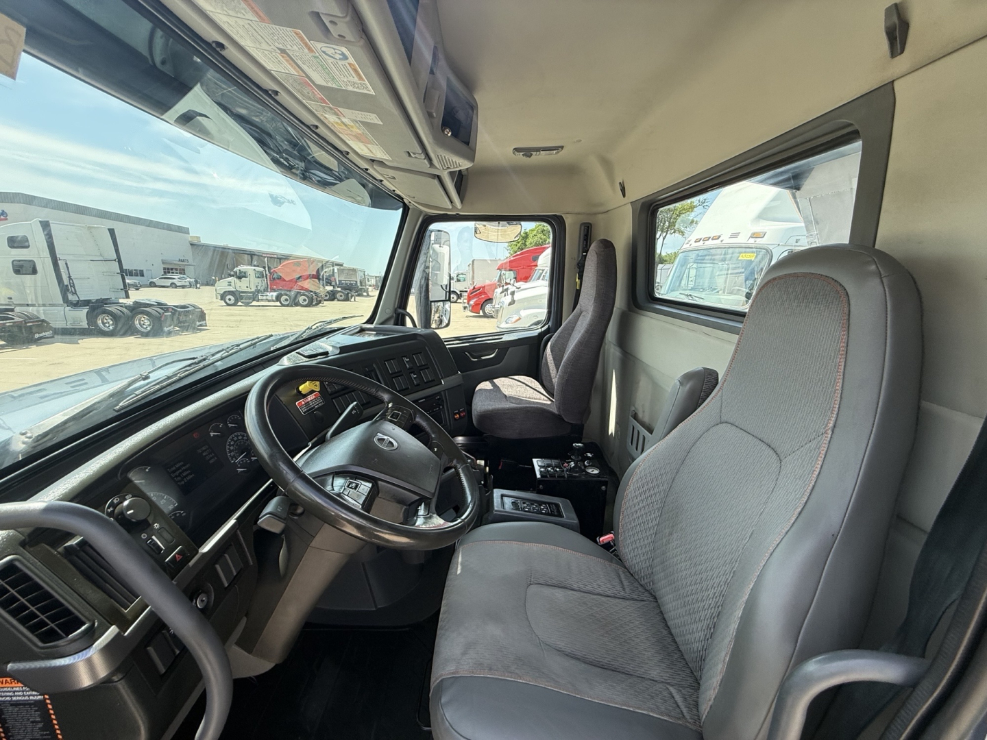 Volvo VHD104F300 truck cab interior showing steering wheel, dashboard, and two front seats.