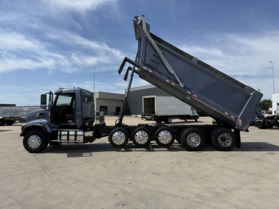 Side view of a Volvo VHD dump truck with a raised dump bed on a multi-axle rear, showing the cab and six rear wheels.