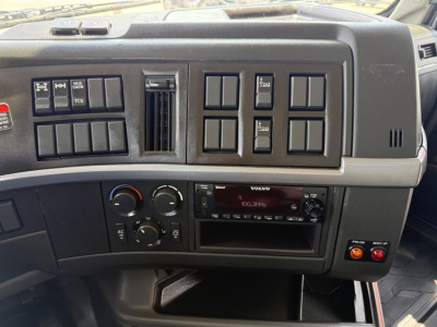 Volvo VHD104F300 truck dashboard with multiple switches and a Volvo radio unit.