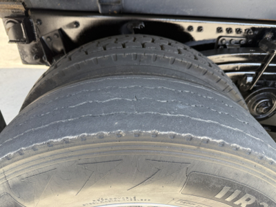 Volvo VHD104F300 dump truck rear axle and dual tires with visible tread and undercarriage components.