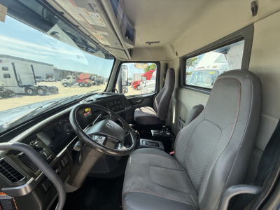 Volvo VHD104F300 truck cab interior showing steering wheel, dashboard, and two front seats.